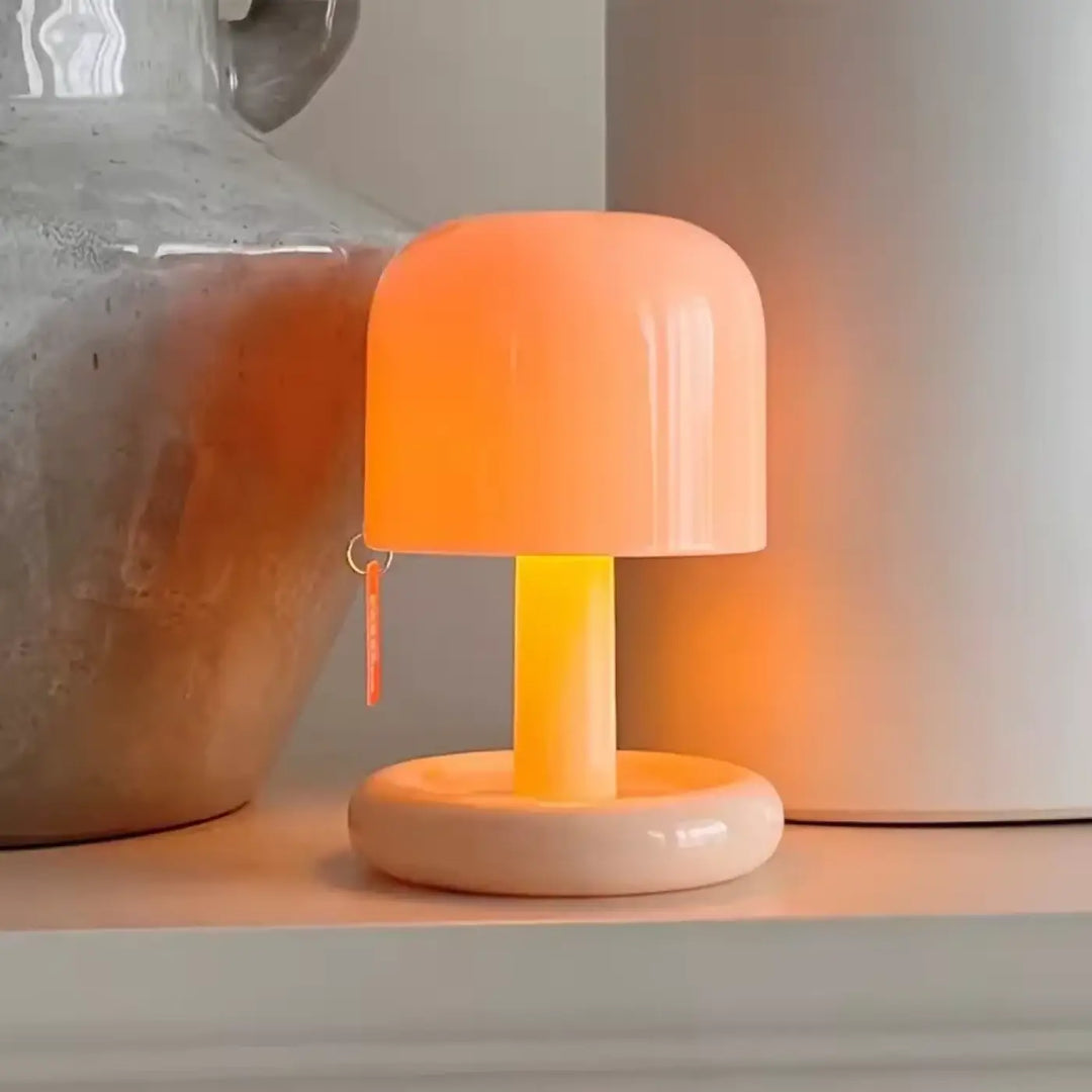 Lampe de chevet milly en plastique lisse et brillant couleur pêche avec base circulaire parfaite pour un chevet crépusculaire c’est choisir élégance