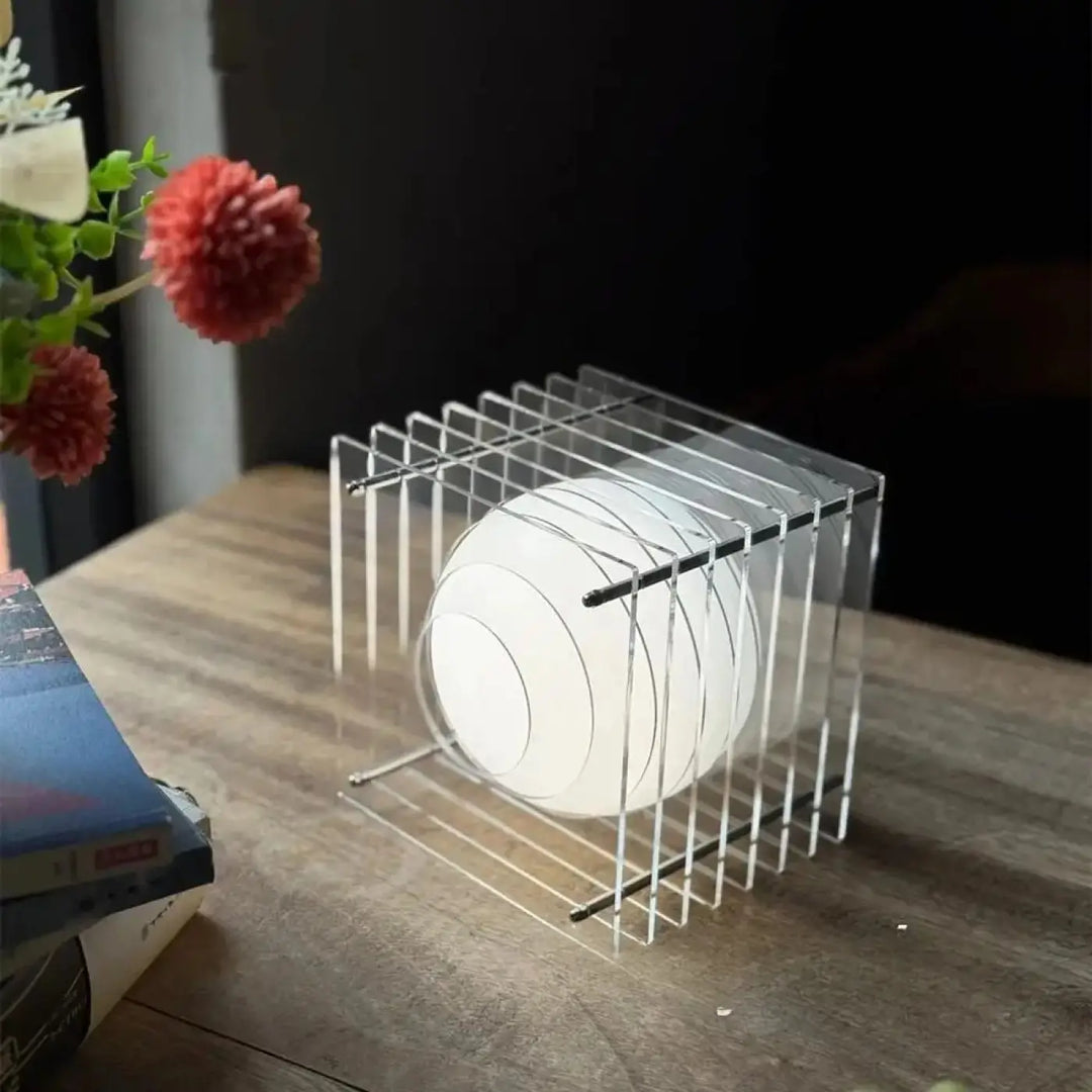 Lampe de chevet cube design avec sphère lumineuse blanche en acrylique dans une cage géométrique transparente univers déco