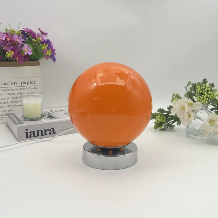 Lampe de chevet lange avec lumière douce orange sphérique à finition brillante sur base chrome pour éclairage chaleureux