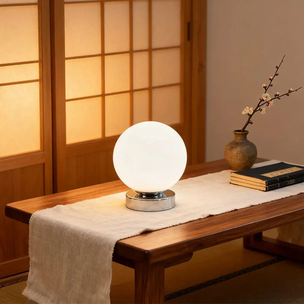 Lampe de chevet lange avec lumière douce sphérique blanche et base en chrome poli pour un éclairage chaleureux plus qu’un simple luminaire