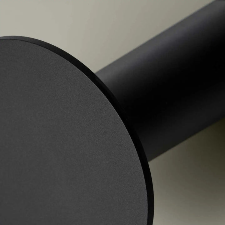 Matte black cylindrical table leg with smooth modern finish of lampe cocktail featuring variation tactile and tête orientable
