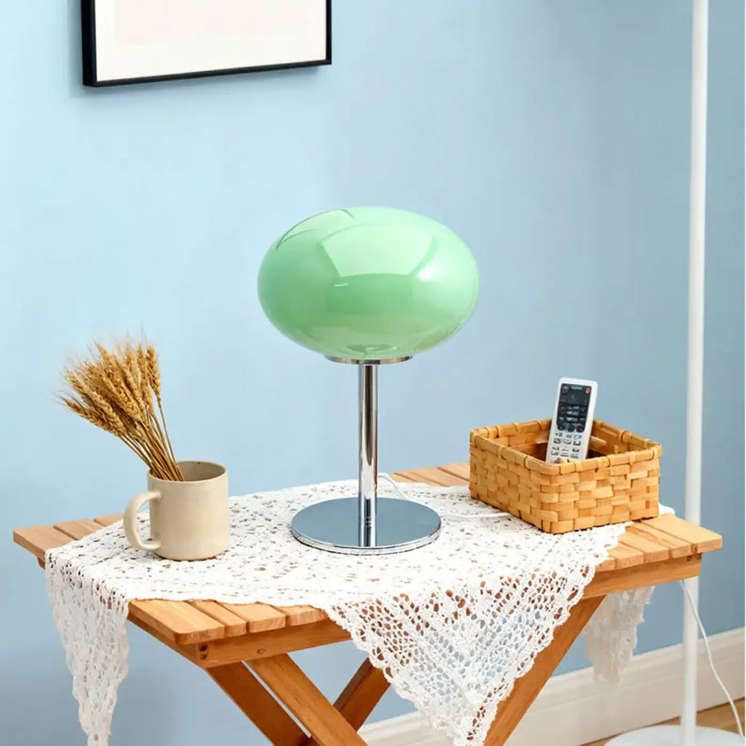 Lampe de chevet minimaliste en verre vert menthe avec base et tige chrome sur table en bois lumière devient design élégant plus qu’un luminaire