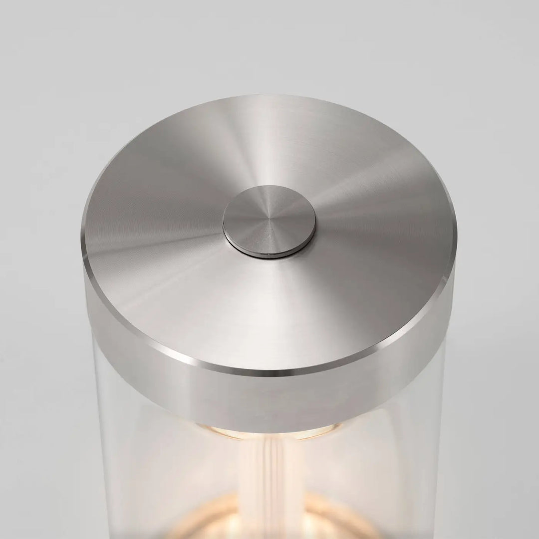 Détail de la lampe de chevet Takeout en acier, allumée #couleur_argent