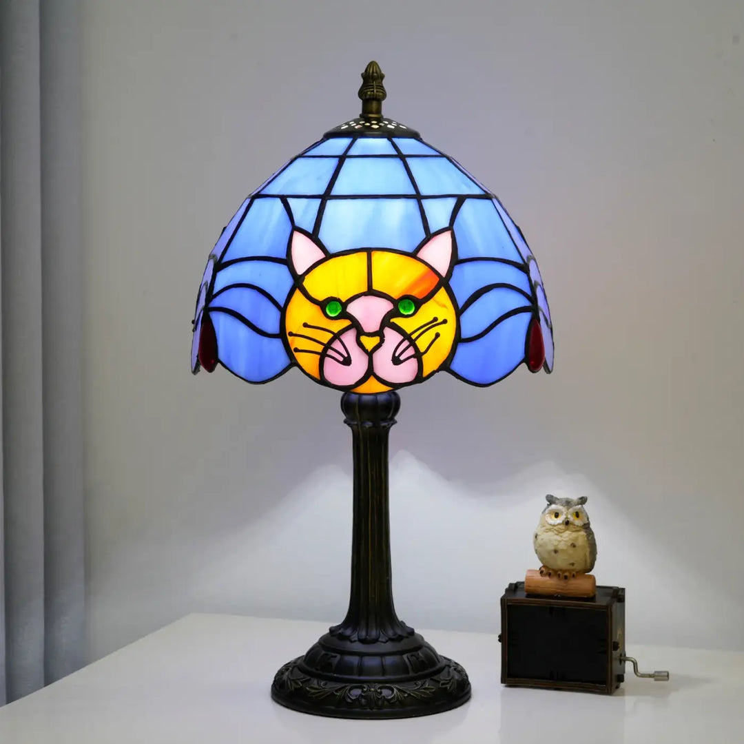 Lampe de chevet miaou en verre teinté bleu et jaune avec visage de chat vert et base en métal orné sombre