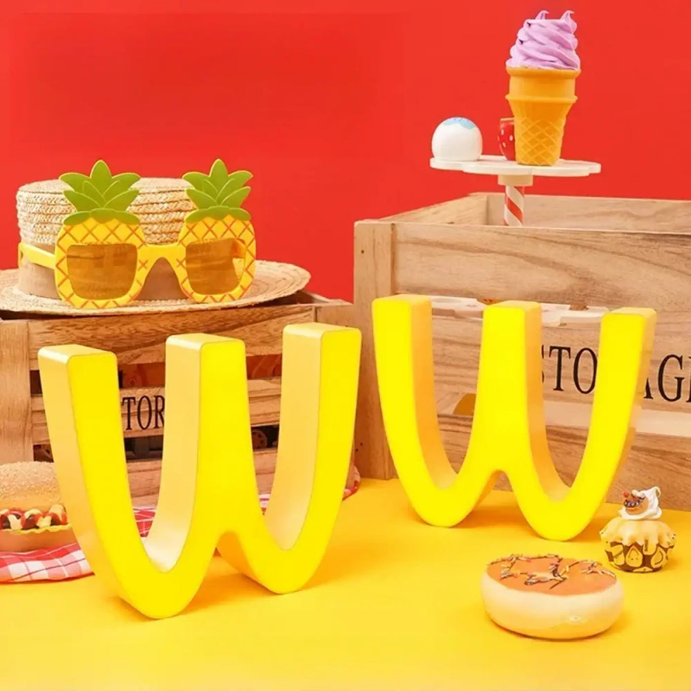 Lampe décorative cartoon en forme de lettre w jaune vif en relief attire l’attention dans un intérieur moderne