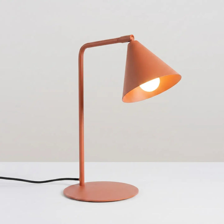 Lampe à poser ocre rouge allumée