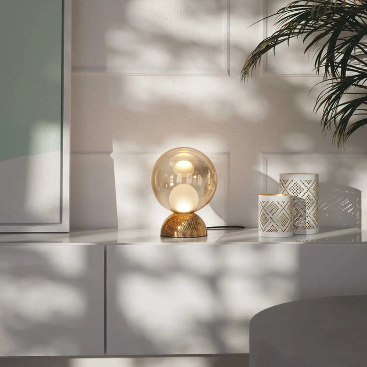 Lampe de chevet charme avec sphère lumineuse cachée en verre ambré et base dorée texturée compacte à poser charm
