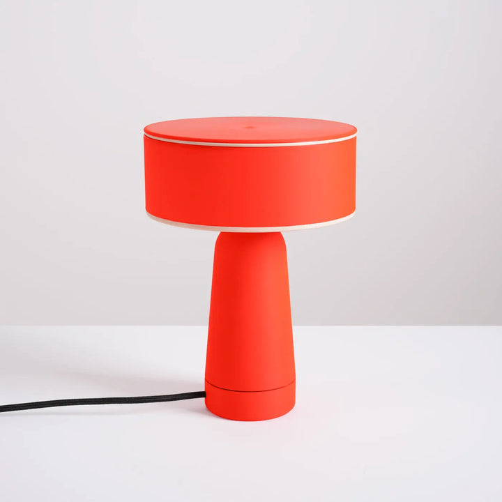 Lampe à poser AXO rouge éteinte, sur un meuble