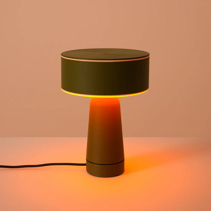 Lampe à poser AXO vert olive allumée, sur un meuble