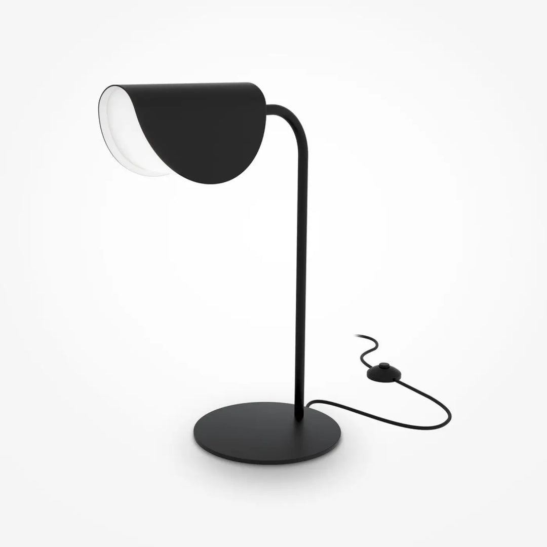 Lampe de chevet mollis avec réflecteur feuille en acier noir et lumière douce sur un socle circulaire minimaliste