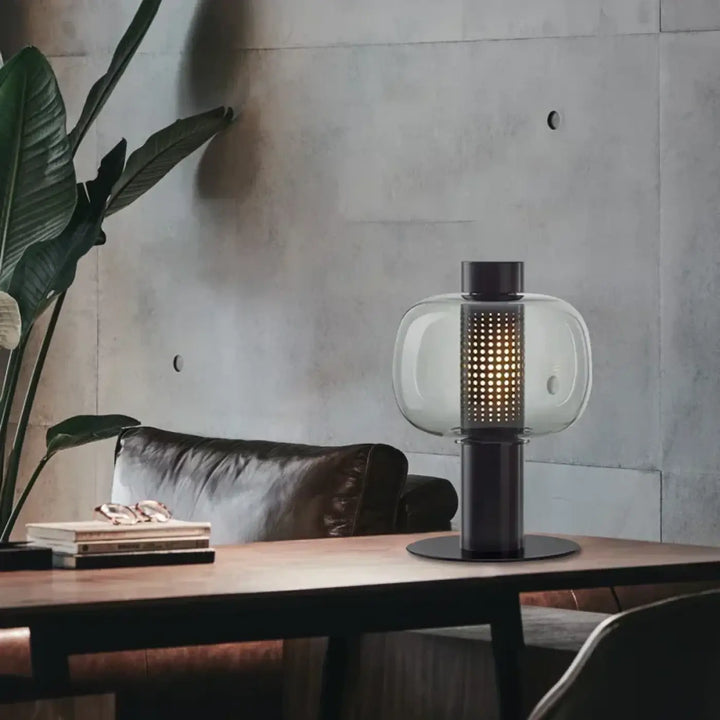 Lampe de table vetra avec globe en verre coloré clair, base en métal noir et colonne perforée lumineuse design moderne
