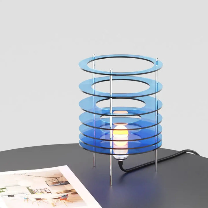 Lampe de table krona avec anneaux superposés en acrylique bleu translucide et supports métalliques chrome pour décoration intérieure et table design