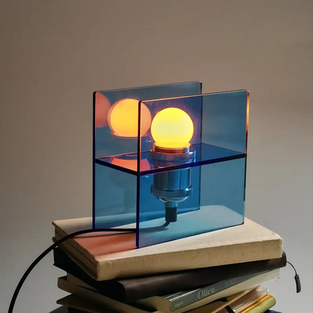 Lampe de chevet anura avec cube acrylique bleu translucide et deux ampoules jaunes pour une lumière douce et esthétique contemporaine