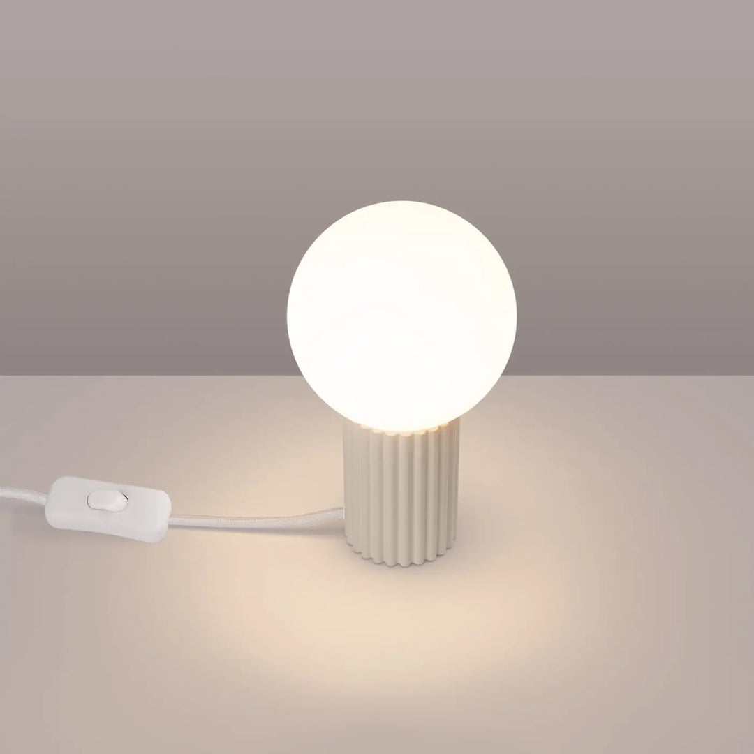Lampe halo beige avec base cylindrique cannelée en verre laiteux émettant une lumière chaude douce version suspension
