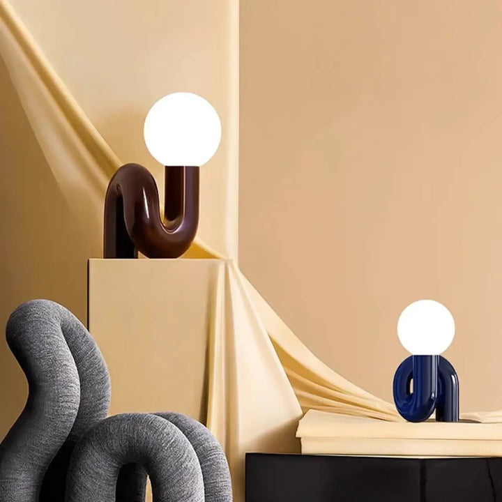 Lampe de table yeimy avec base incurvée brillante bleu marine et globe en verre blanc pour décoration intérieure chic