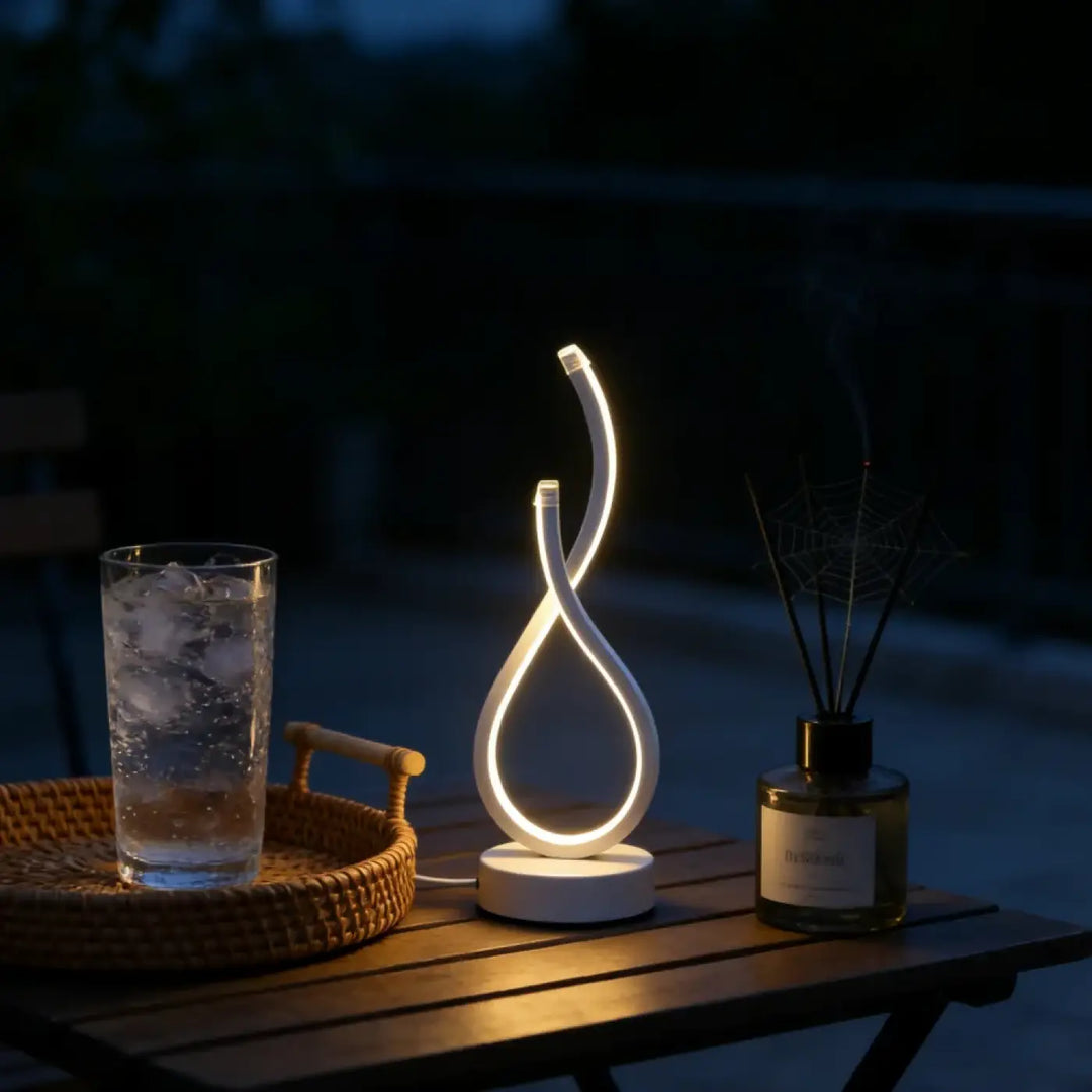 Lampe de table infinia blanche à boucle lumineuse moderne avec silhouette sculpturale posée sur table en bois