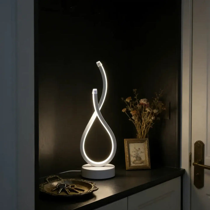 Lampe de table infinia avec boucle lumineuse blanche led et silhouette sculpturale moderne en design table