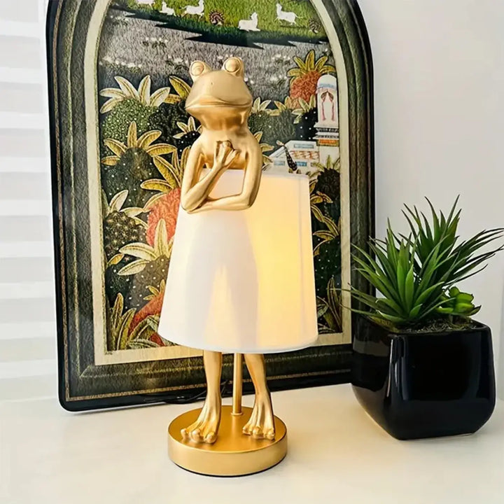 Lampe de table amphoria design grenouille en forme de grenouille dorée avec abat-jour conique blanc et pieds métalliques fins