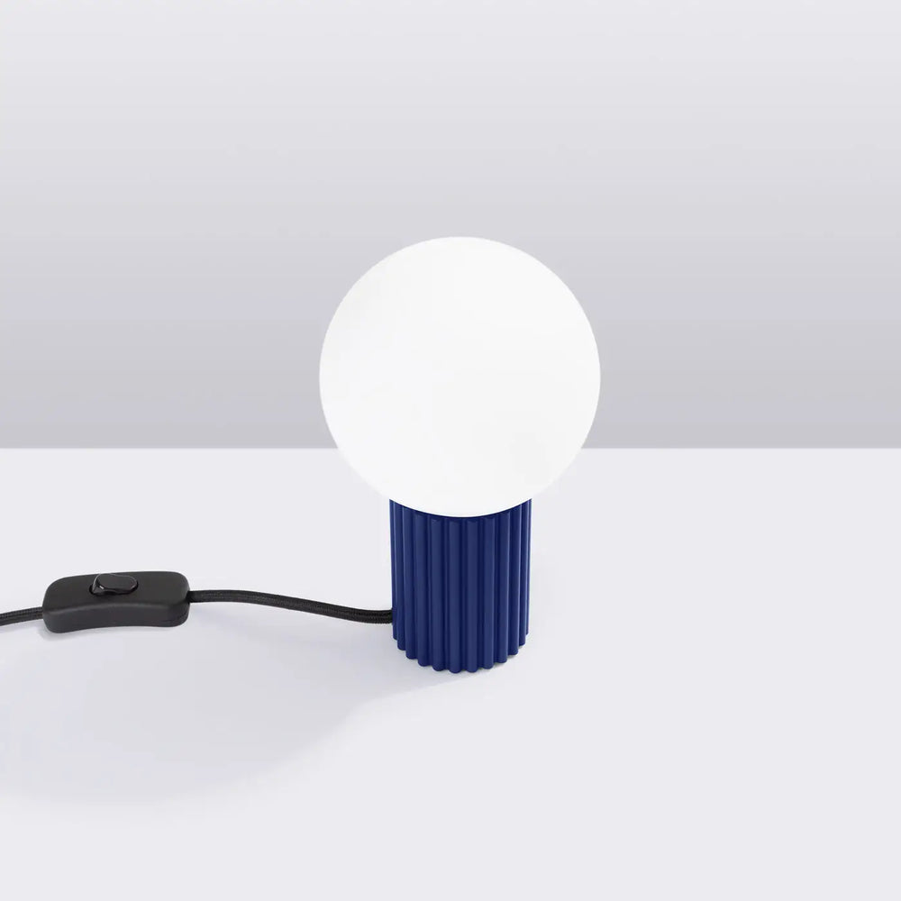 Lampe halo poser halo outremer avec base cylindrique côtelée bleu marine et ampoule sphérique blanche opaque version suspension