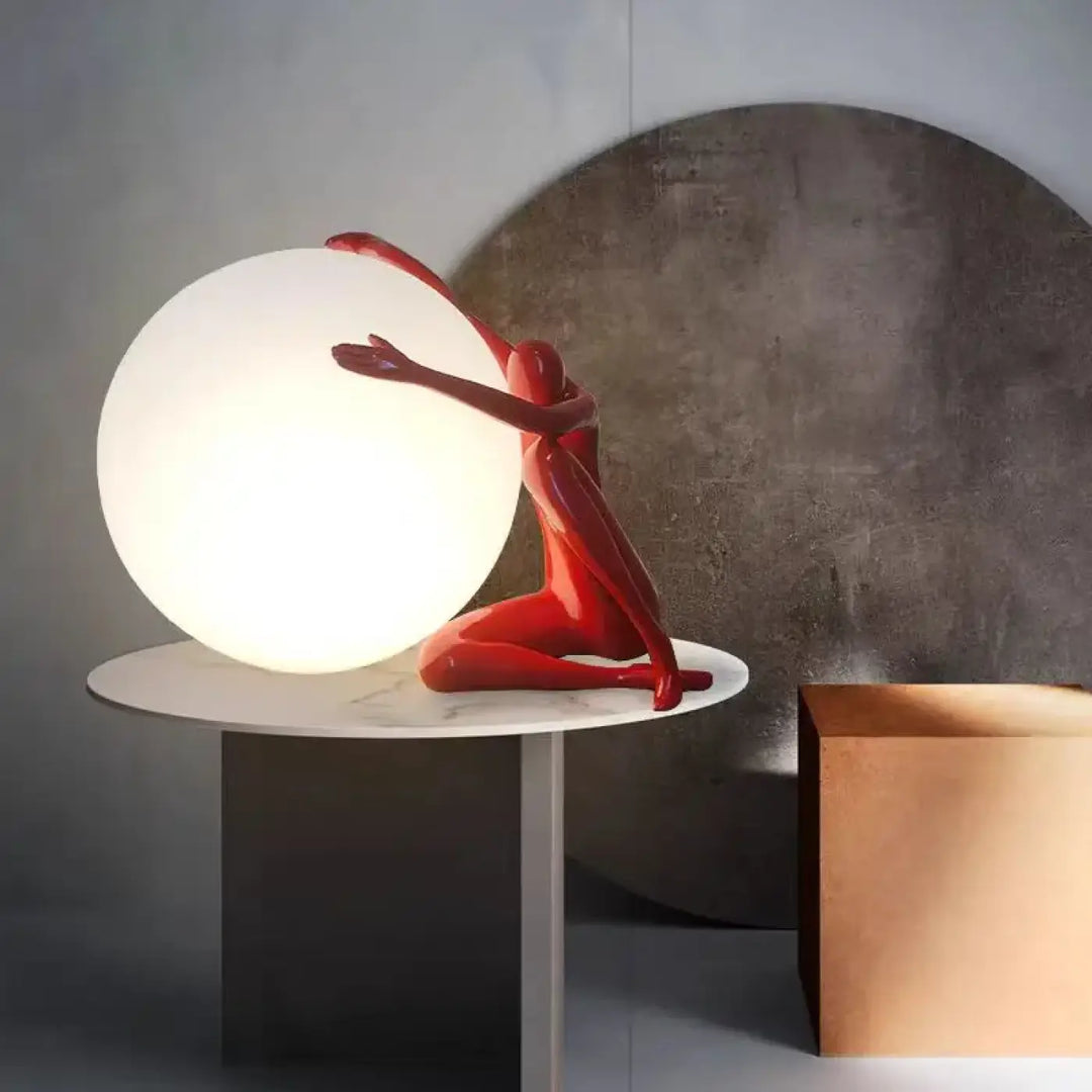 Lampe de table kelya en résine rouge brillant avec silhouette enlacée tenant une lumière sphérique blanche