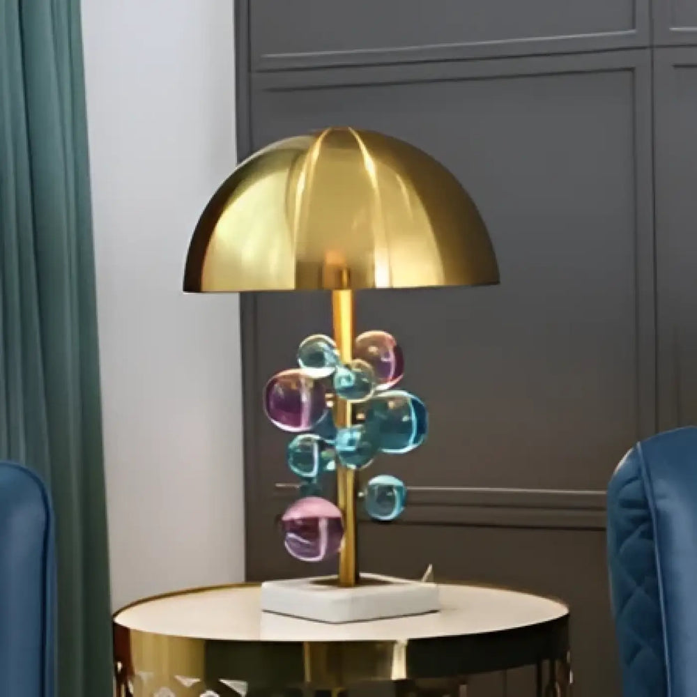 Lampe de table opaly avec dôme doré, tige en laiton et orbes en verre bleu et violet sur socle en marbre blanc, table contemporaine décoration intérieure