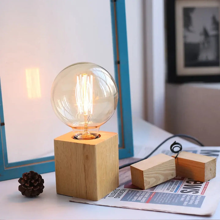 Lampe de table loxia avec ampoule filament sphérique ton chaud sur base carrée en bois pour table en bois