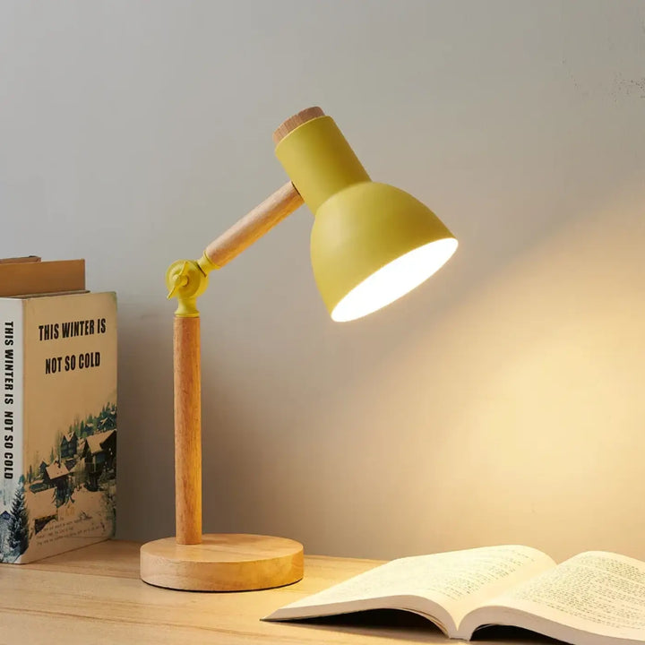 Lampe de table natax en métal jaune chaud avec base en bois et bras articulé éclairant un livre ouvert sont-elles incluses
