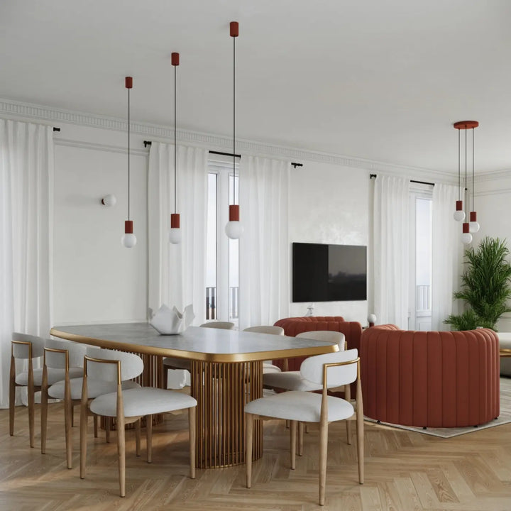 Table à manger moderne avec dessus en marbre et pieds métalliques dorés verticals lampe halo version suspension rouge ochra