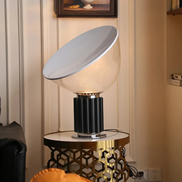 Lampe de table ekoa avec base striée noire, dôme en verre blanc translucide et accents chrome où la lumière devient plus qu’un simple éclairage