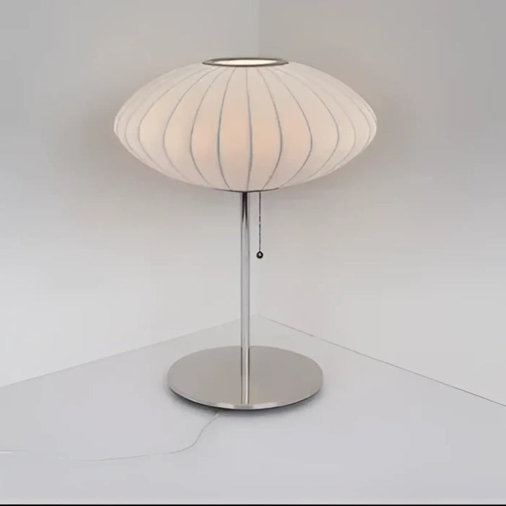 Lampe de table plissy avec abat-jour en tissu côtelé crème et pied métal chrome pour une décoration intérieure sculpturale