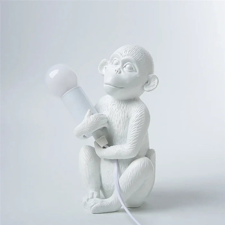 Lampe de table zaboo avec singe assis blanc en résine tenant une ampoule, table sculpturale singe décorative