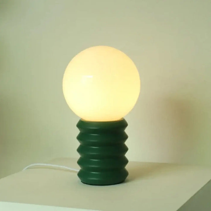 Lampe de table helix avec base spiralée vert foncé en style contemporain et abat-jour sphérique lumineux