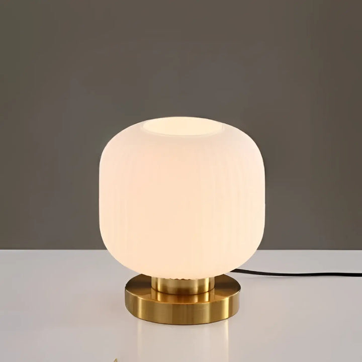 Lampe de table vét y moderne avec globe en verre dépoli cannelé et base en laiton poli les piles sont-elles incluses
