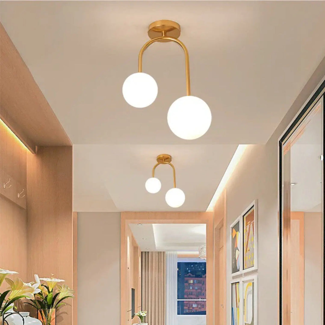 Luminaire plafonnier solia en métal doré avec deux globes en verre blanc pour un design chic et plus classique
