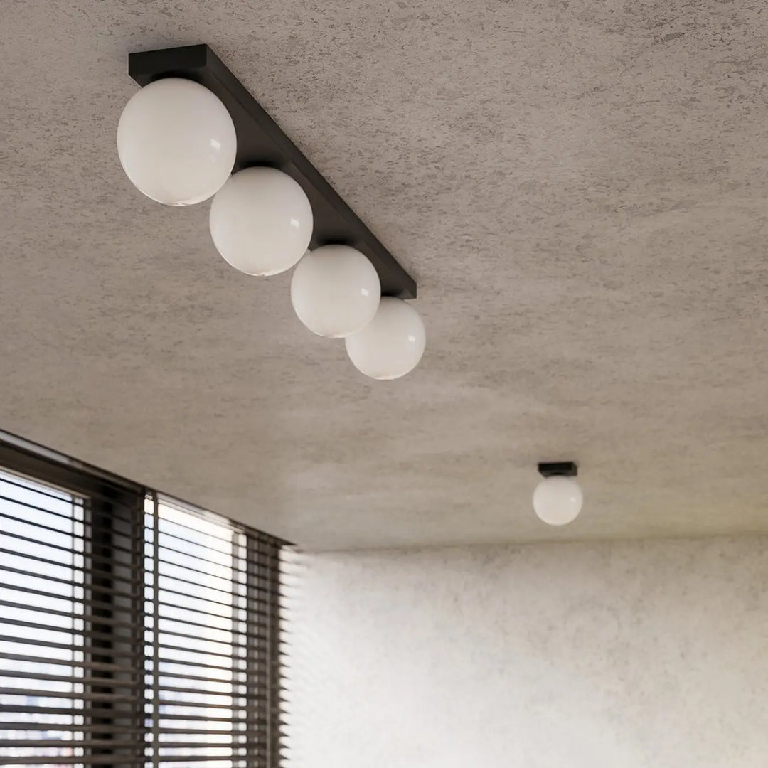 Luminaire plafonnier yoli 3 noir avec quatre globes en verre blanc sphériques pour une classe à part dans votre intérieur