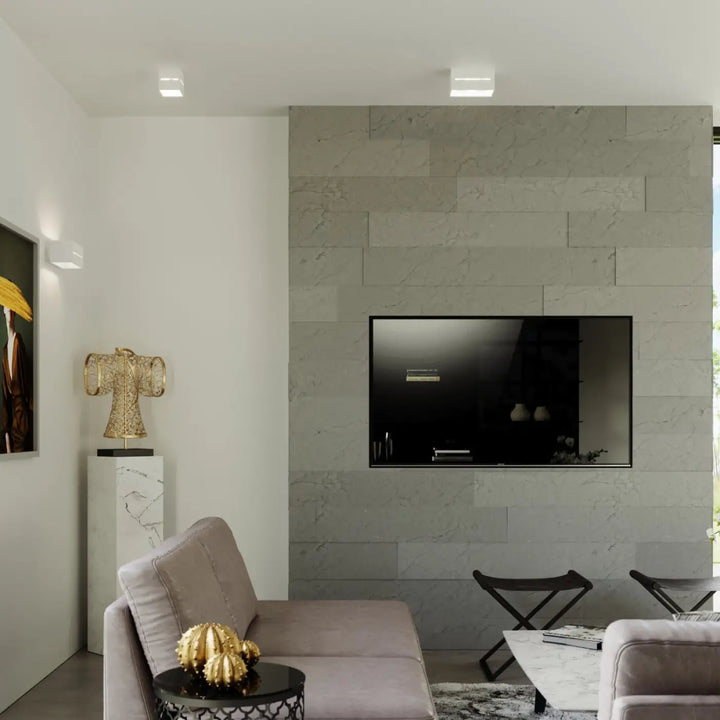 Plafonnier lobo blanc avec spectacle lumineux et perforation linéaire monté sur un mur en marbre gris