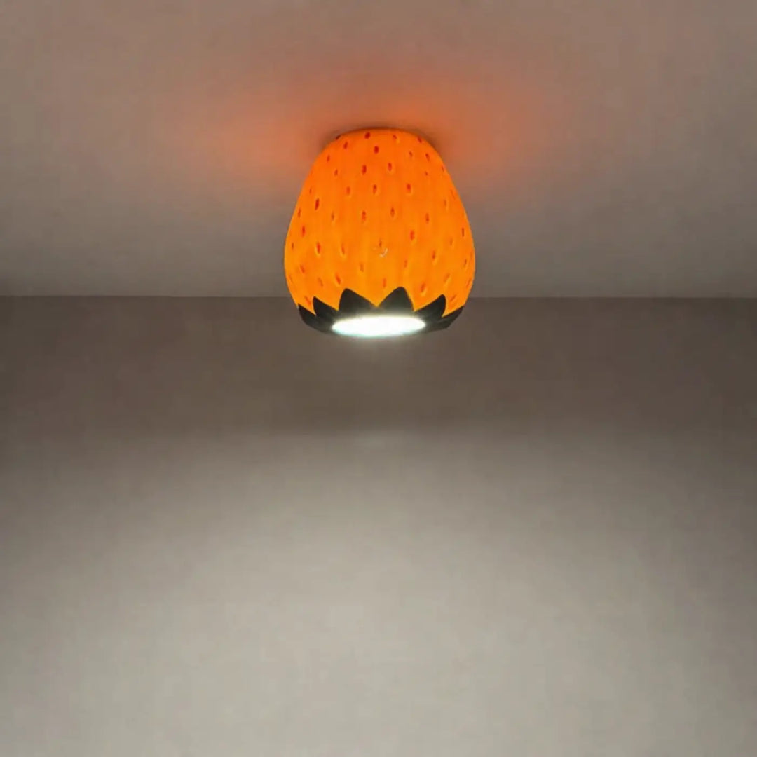 Luminaire plafonnier cosy orange en forme de fraise avec accents de feuilles noires pour un plafonnier cosy design