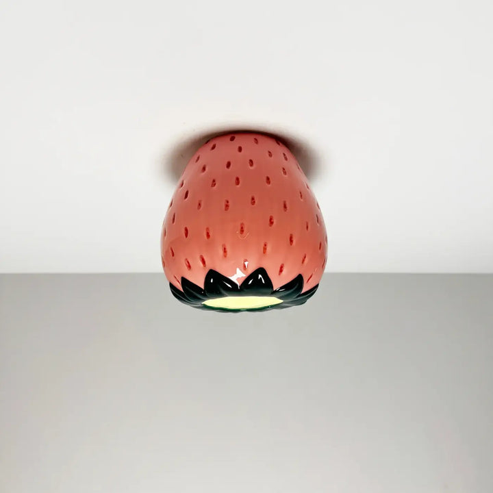 Luminaire plafonnier cosy en céramique rose brillant en forme de fraise avec feuilles noires et base lumineuse jaune
