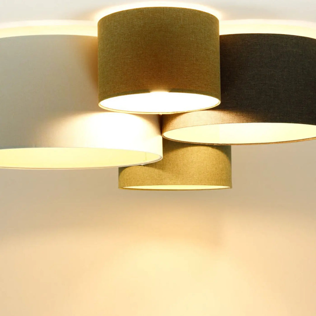 Plafonnier moderne avec quatre abat-jours cylindriques en tissu naturel crème vert gris noir pour intérieur élégant