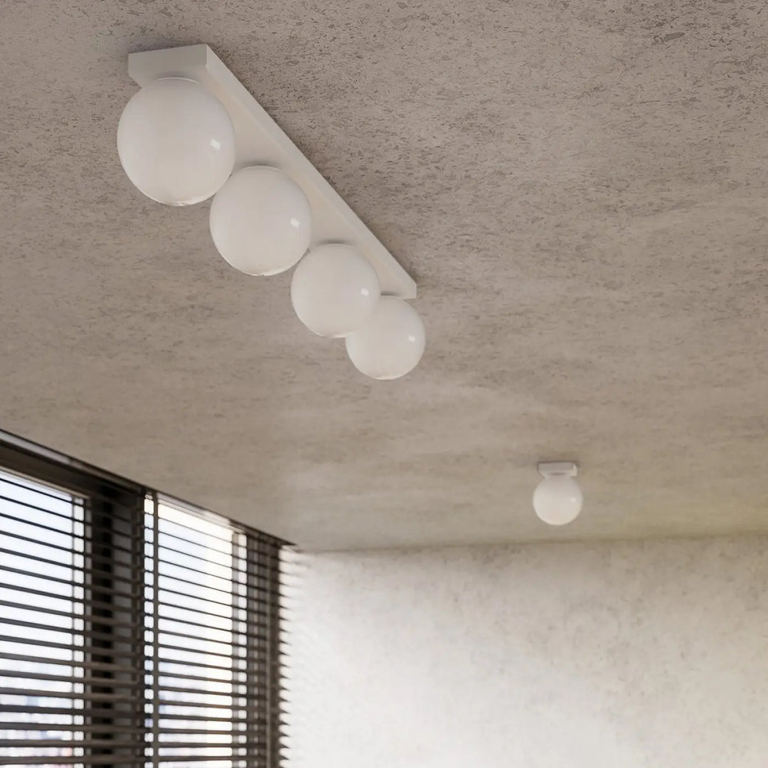Plafon yoli luminaire plafonnier blanc avec quatre globes sphériques sur barre rectangulaire minimaliste classe à part