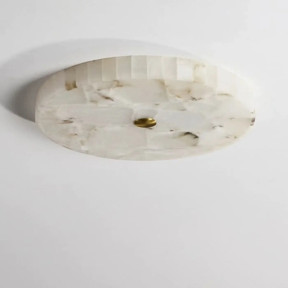 Plafonnier design circulaire en pierre nacrée blanc avec texture facettée et accent central en laiton pour décoration intérieure