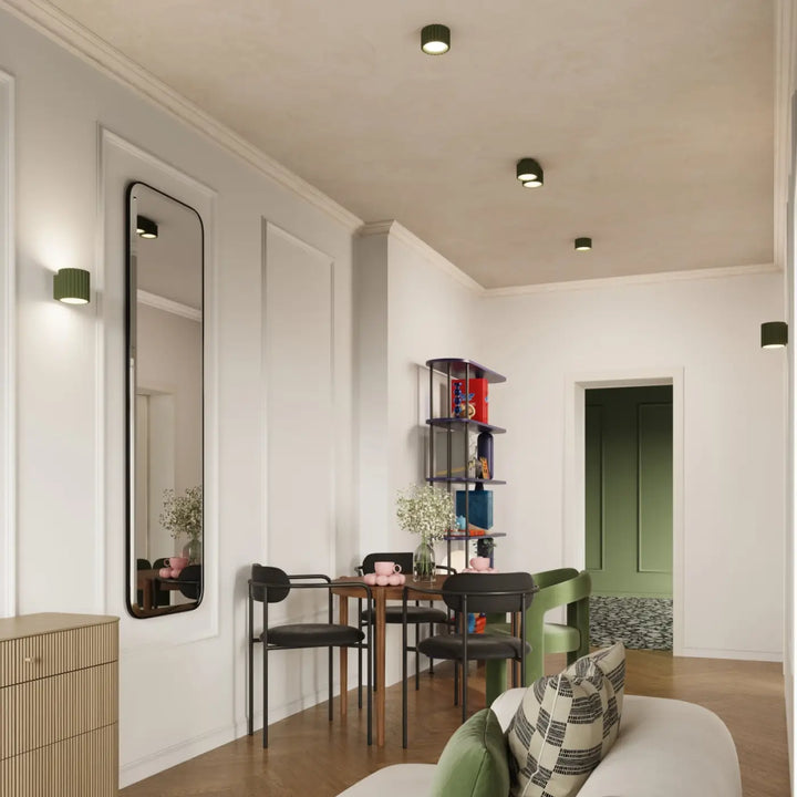 Miroir rectangulaire long avec cadre noir reflétant la forme unique inspirée du luminaire plafonnier aura 2 vert olive