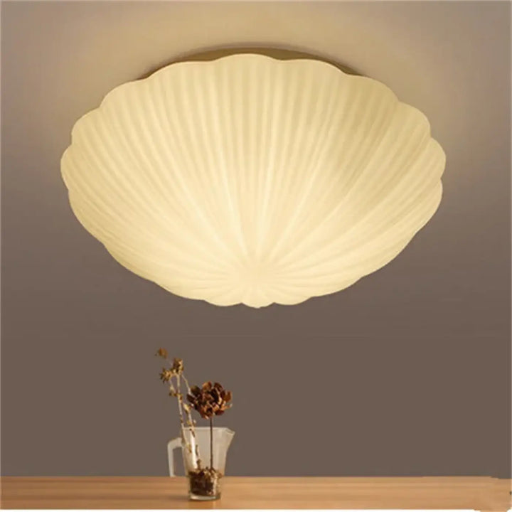 Luminaire plafonnier concha crème en forme de coquillage avec texture côtelée offrant un éclairage diffus doux