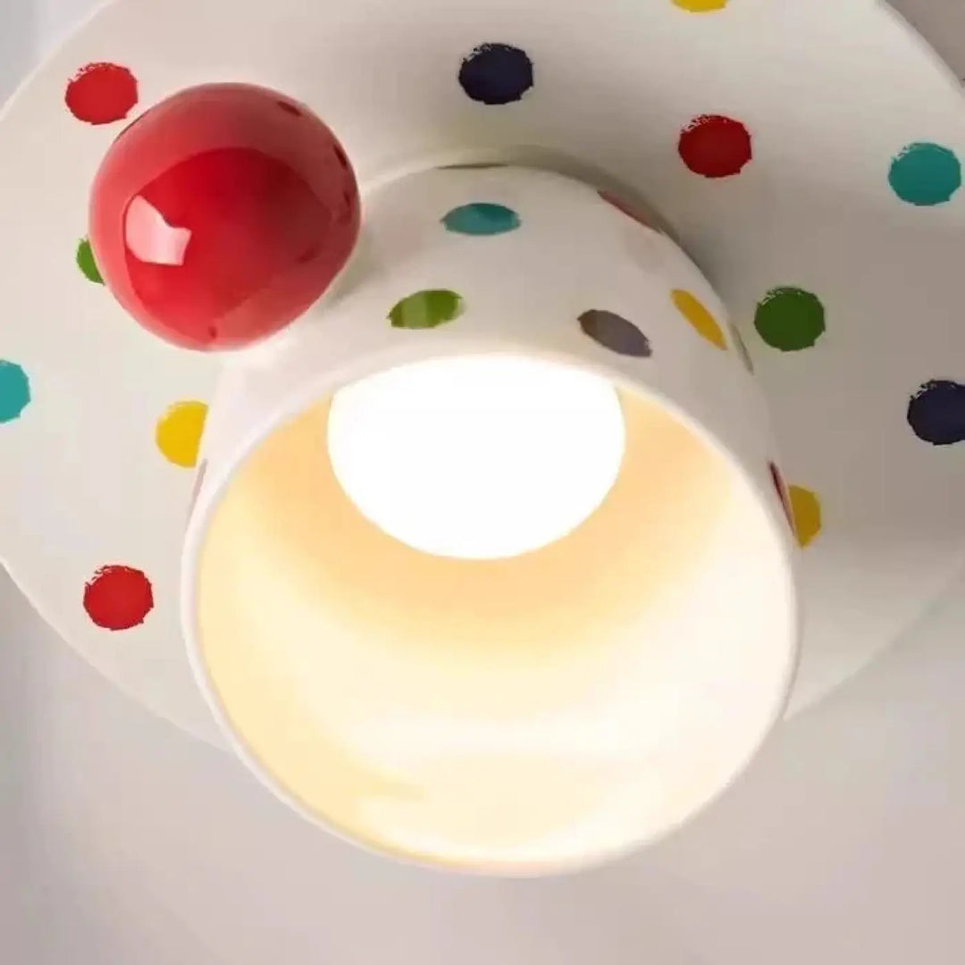 Luminaire plafonnier en céramique blanche avec tasse à pois colorés et accent sphérique rouge qui donne envie