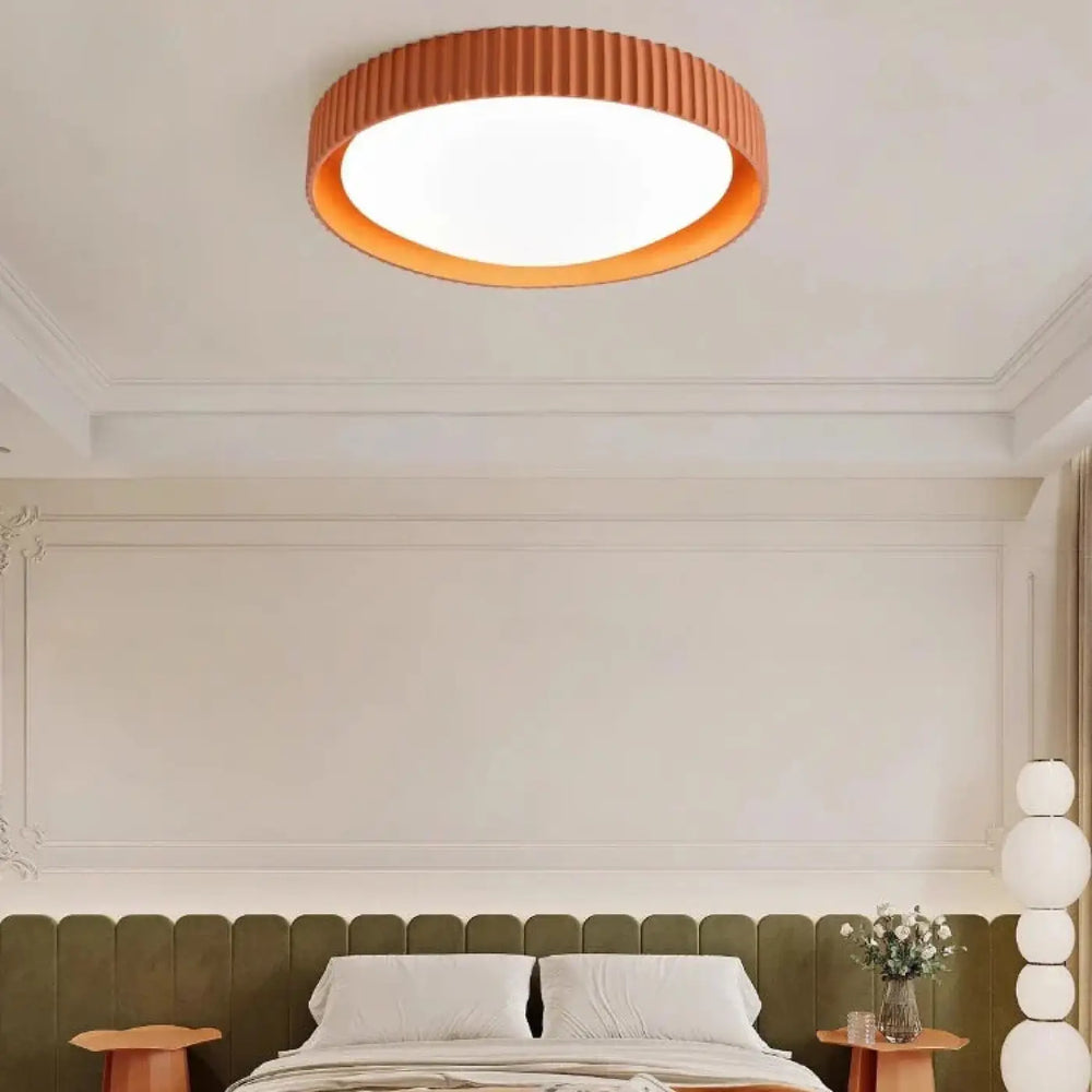 Luminaire plafonnier stria orange à texture côtelée avec reliefs graphiques diffusant une lumière chaleureuse