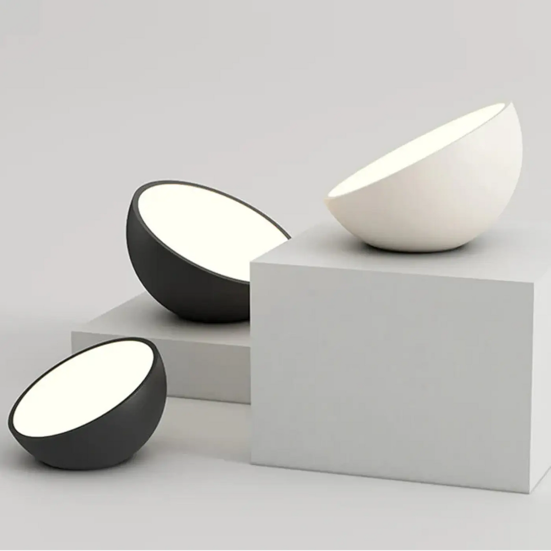 Luminaire plafonnier cosma avec coque arrondie en céramique mate noire et blanche diffusant une lumière diffuse douce
