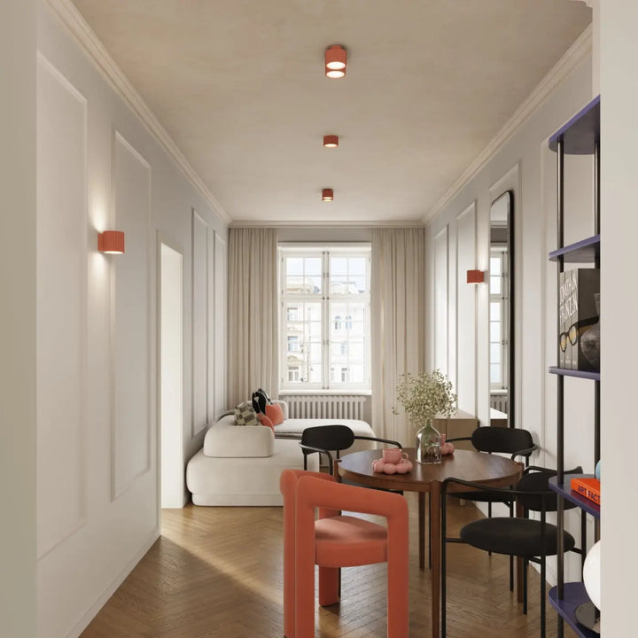 Luminaire plafonnier aura 1 peach avec forme unique inspirée et table à manger ronde en bois foncé avec chaises contrastées