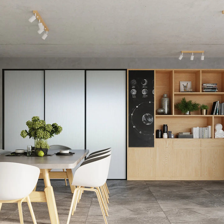 Table à manger moderne avec surface grise et pieds en bois clair sous plafonnier verdo design moderne blanc