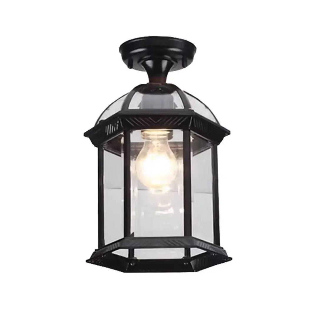 Luminaire plafonnier vintage en métal noir avec lanterne en fer forgé et ampoule à lumière chaude visible à travers verre clair