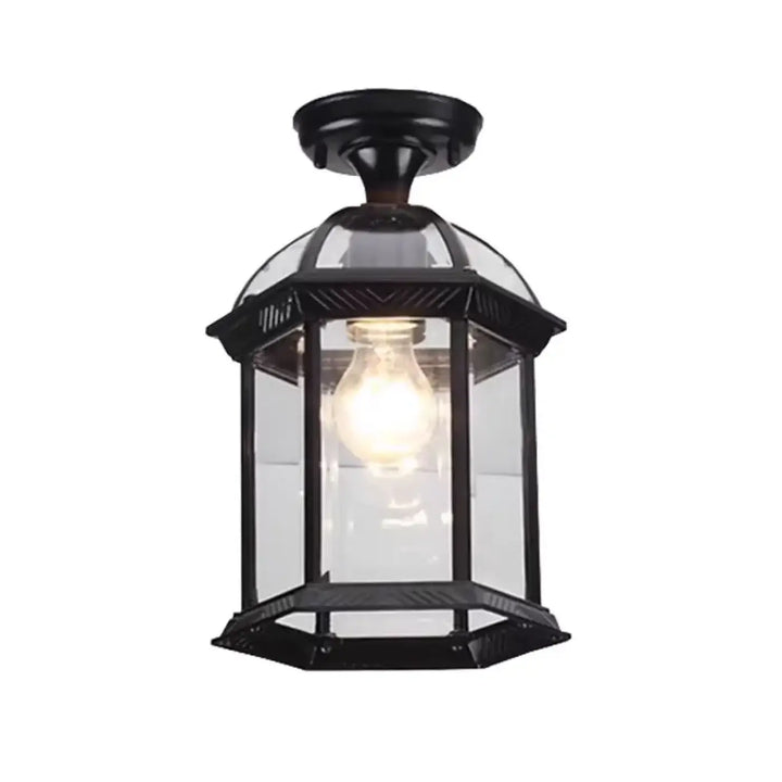 Luminaire plafonnier vintage en métal noir avec lanterne en fer forgé et ampoule à lumière chaude visible à travers verre clair